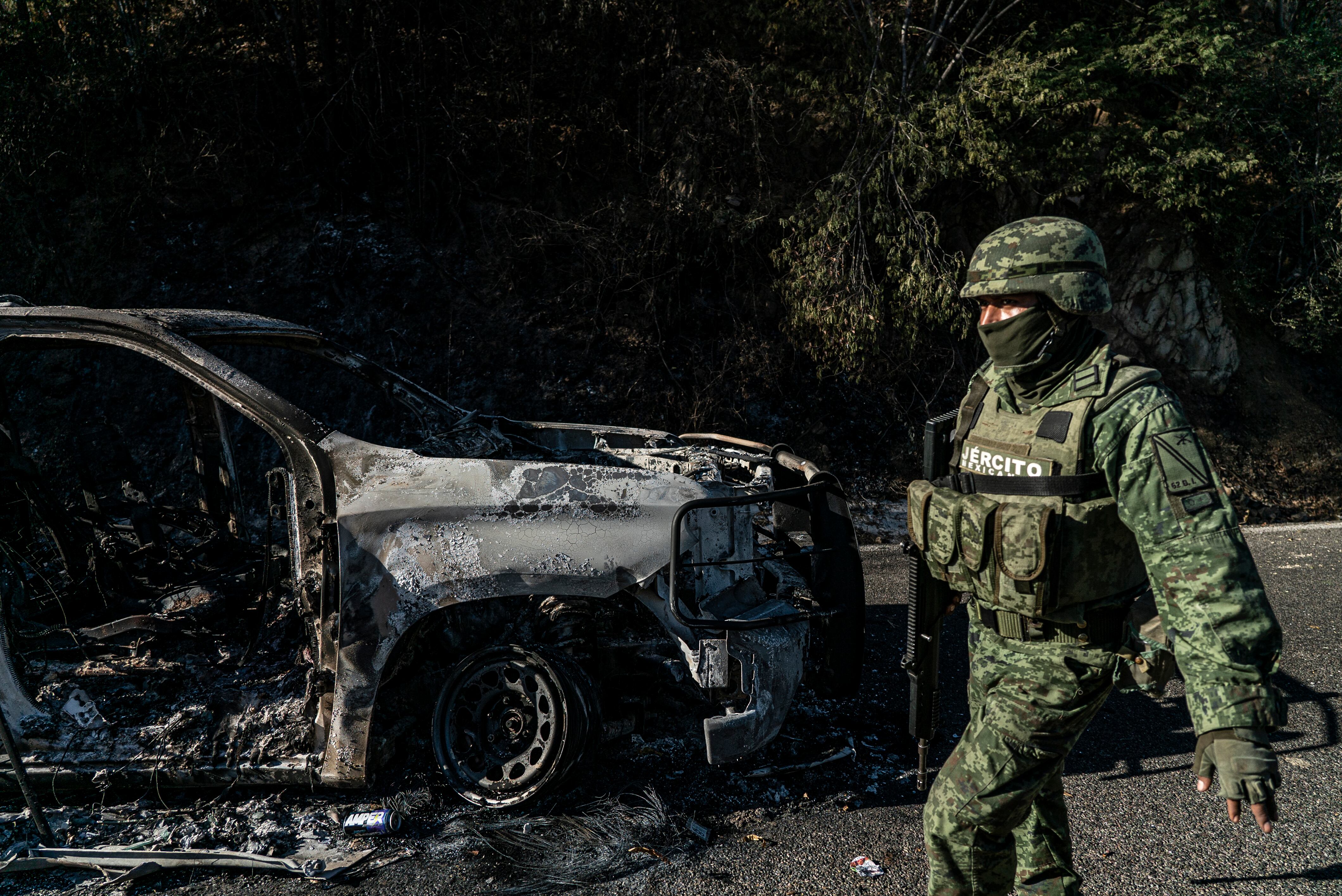 A Mexican soldier walks past a torched car in the town of Jesús María, on Saturday, January 7, 2023.
.