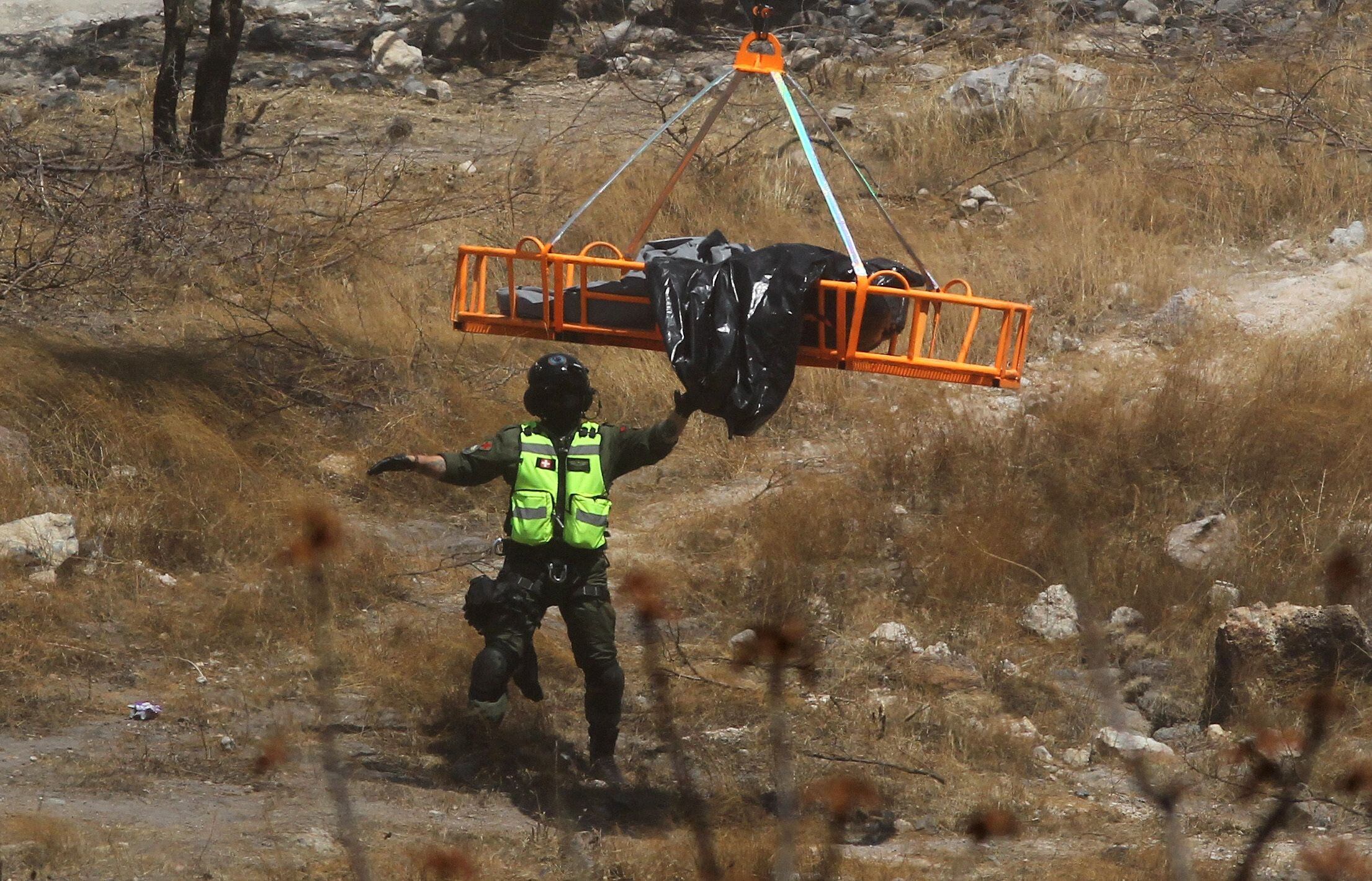 Rescuers and forensics experts remove the bodies found at the bottom of a ravine on May 31 in Zapopan (Jalisco State).