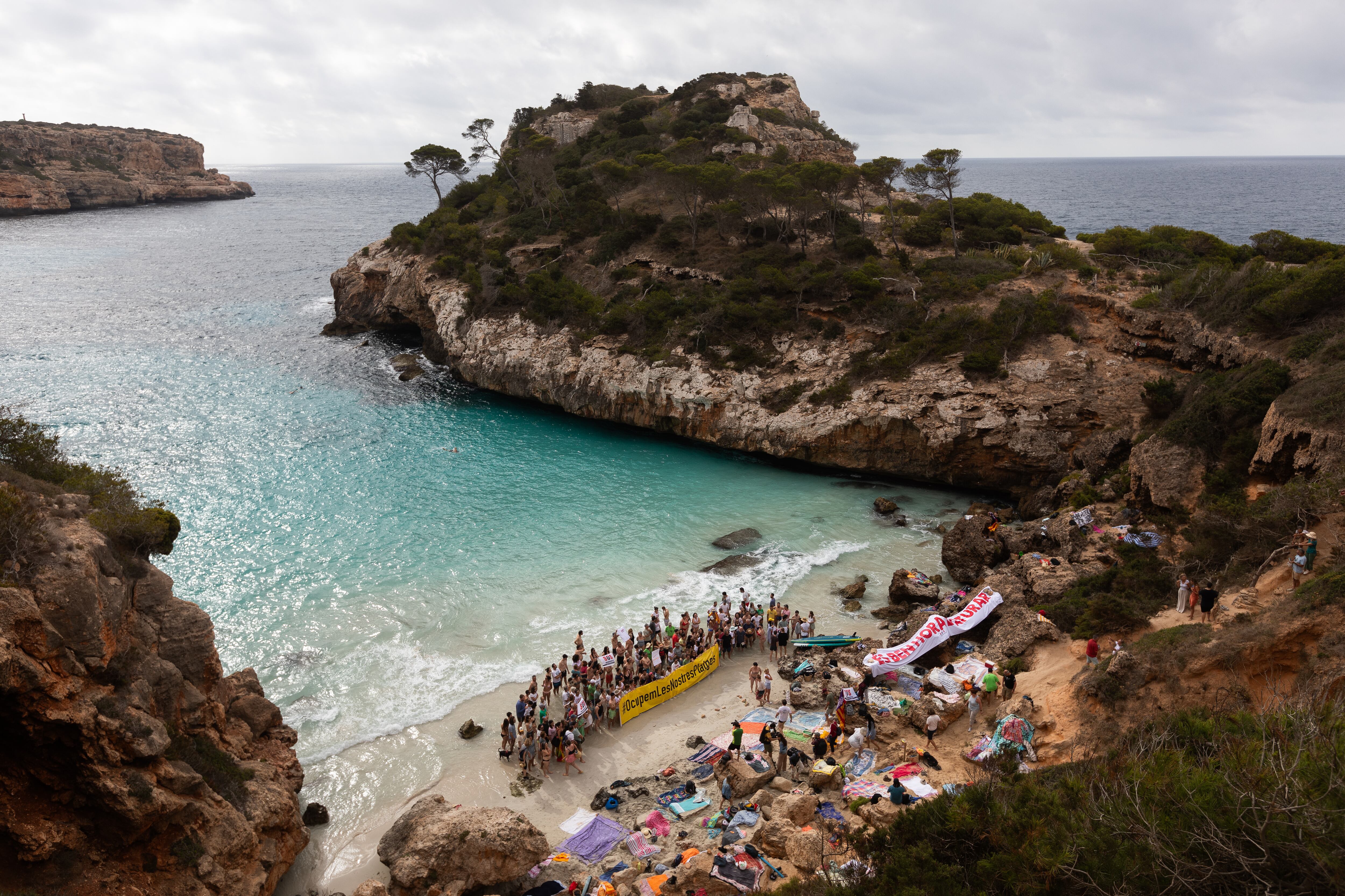 Decenas de personas protestan en Cala del Moro en Mallorca, este domingo.