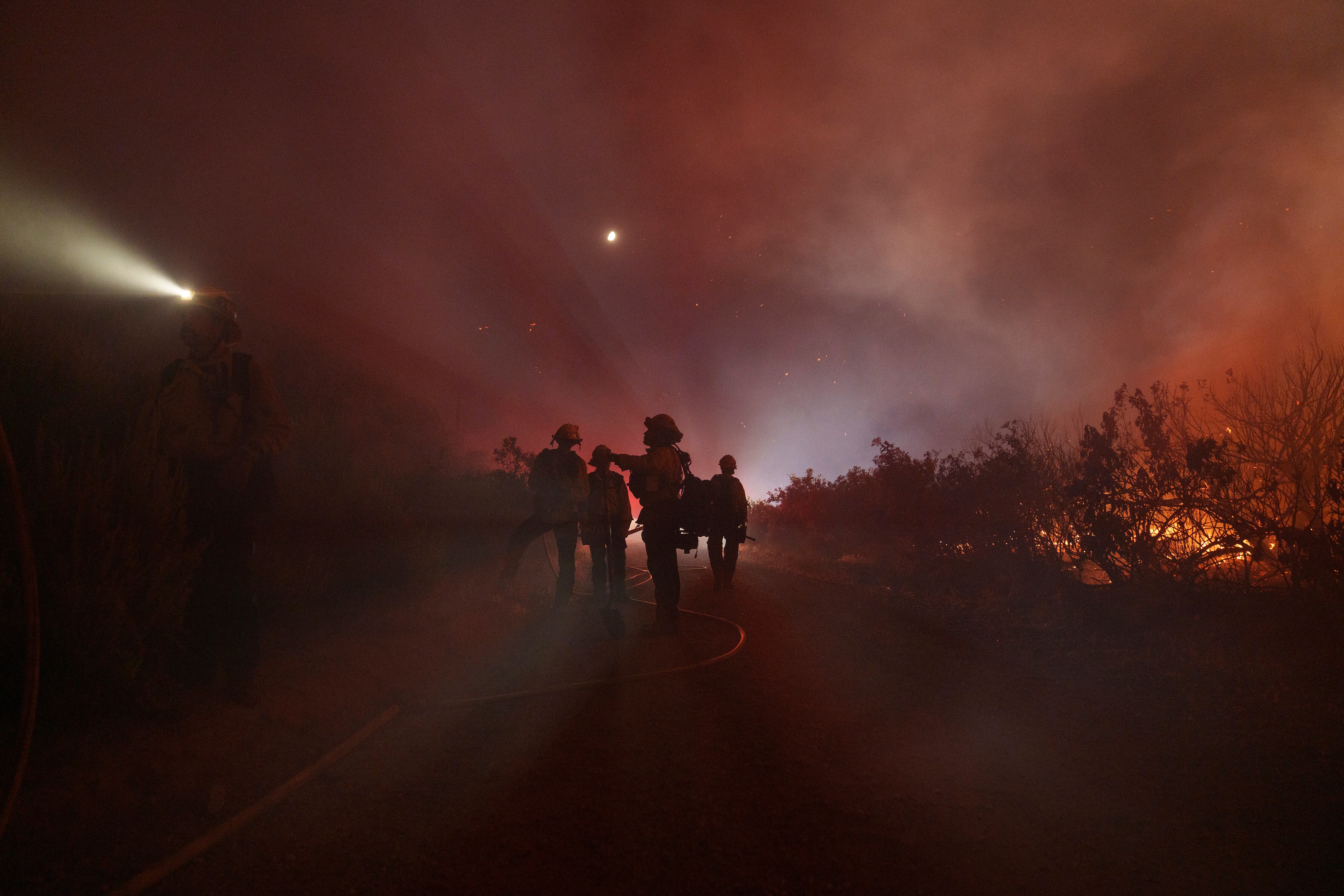 Firefighters work to stop the fire on June 16 in Gorman, California.