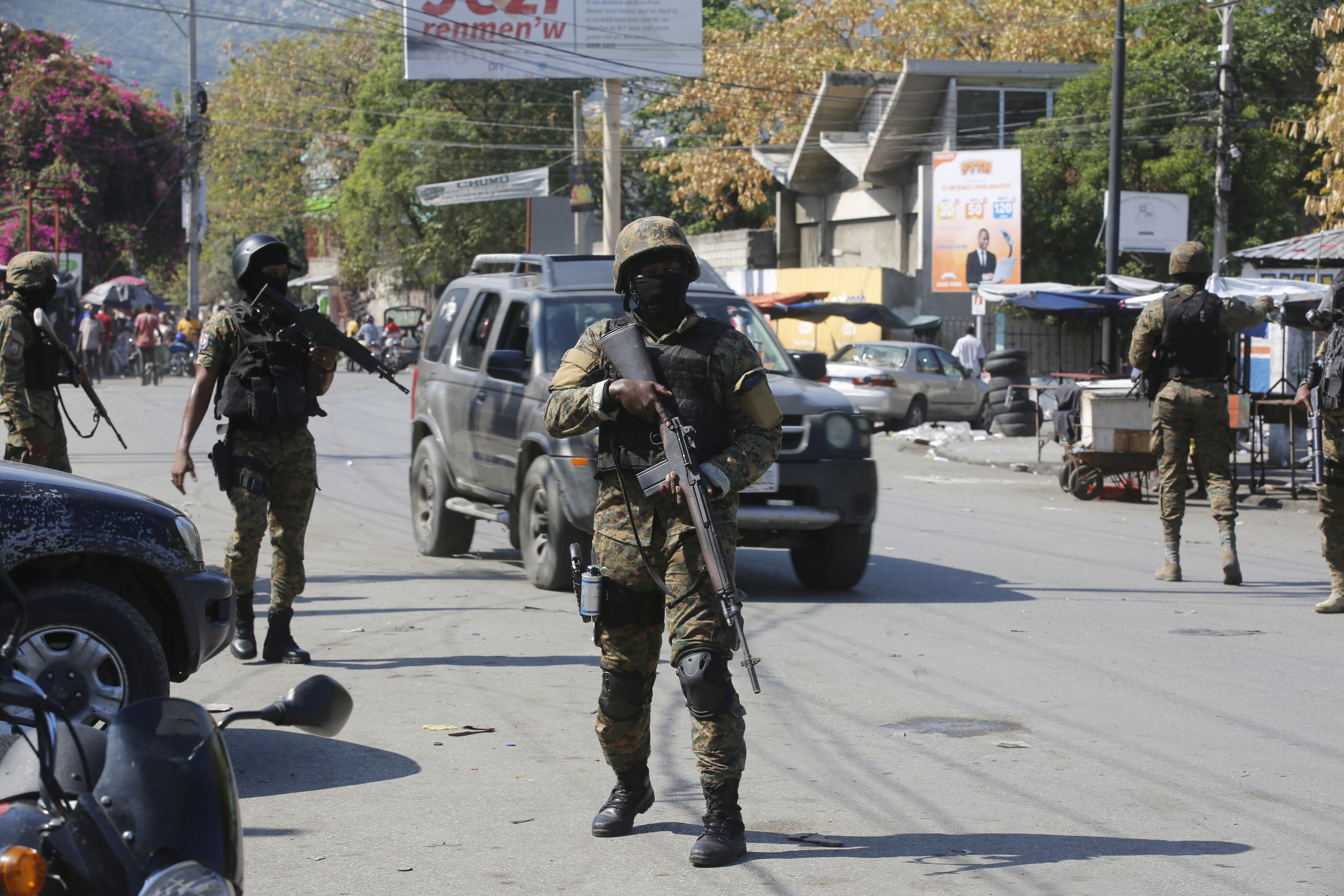 Members of the General Security Unit of the National Palace, USGPN, set up a security perimeter around one of the three downtown stations after police fought off an attack by gangs the day before, in Port-au-Prince, Haiti, Saturday, March 9, 2024.