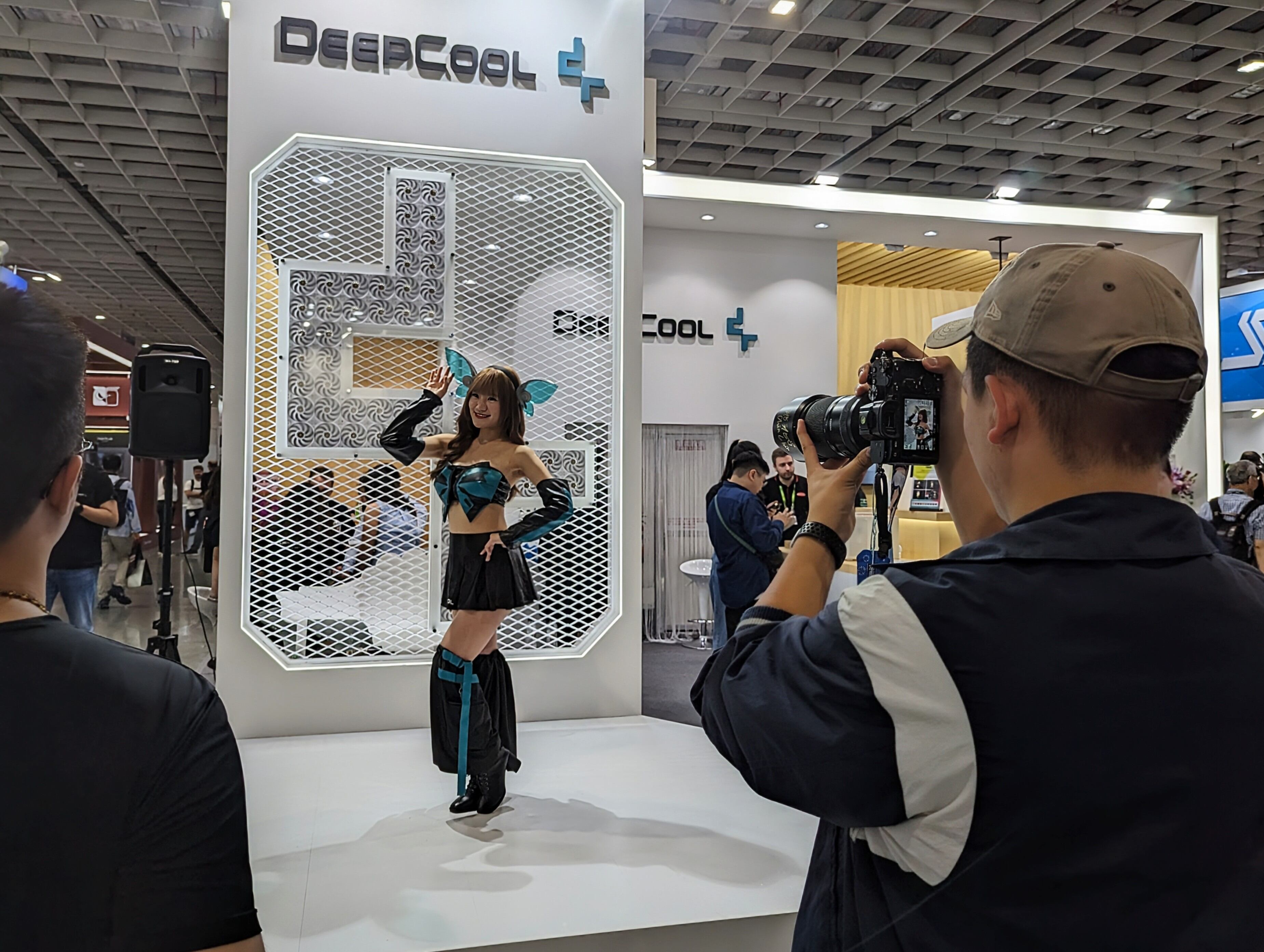 Un hombre le hace una foto a una chica en un stand de Computex.