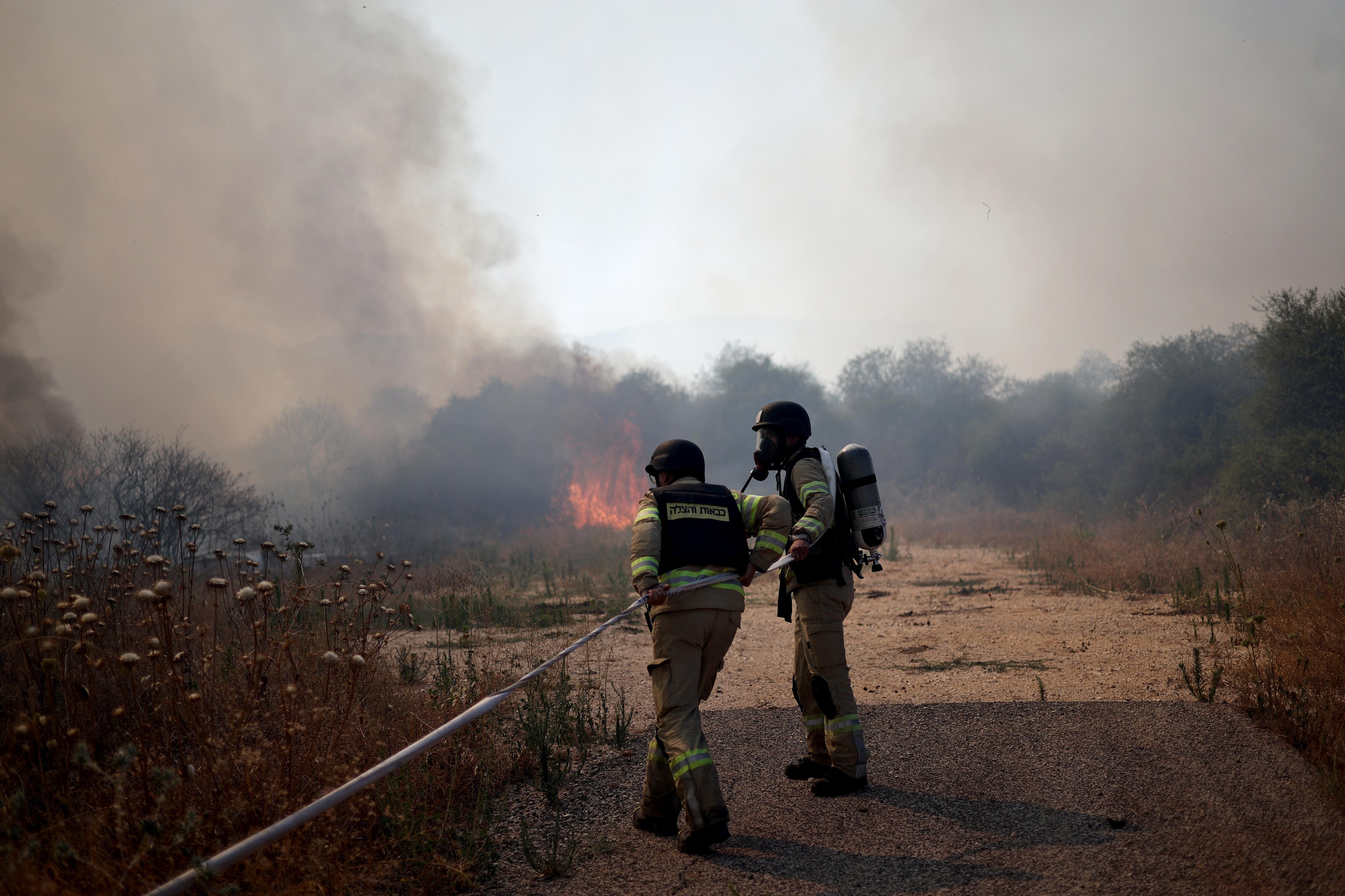 Bomberos israelíes apagan un incendio en Dishon, en el norte del país, después de que se interceptara un objetivo aéreo que cruzó desde el Líbano, este martes.