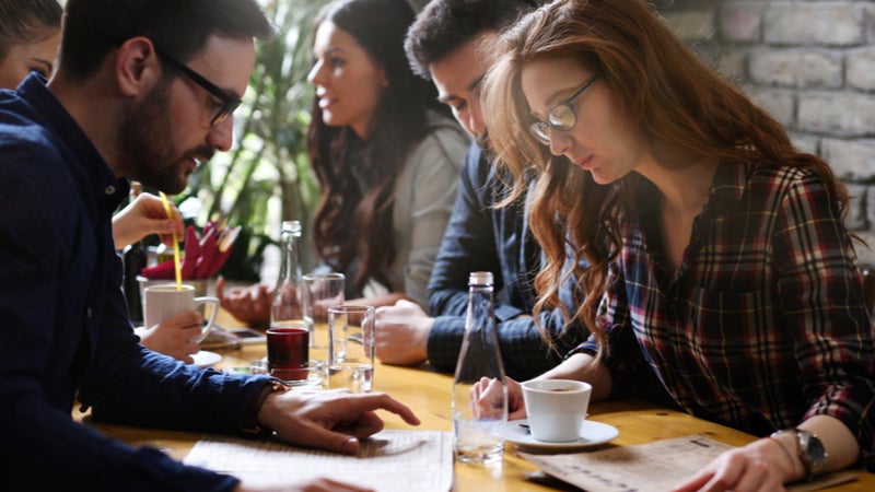 Young people looking at menu in restaurant