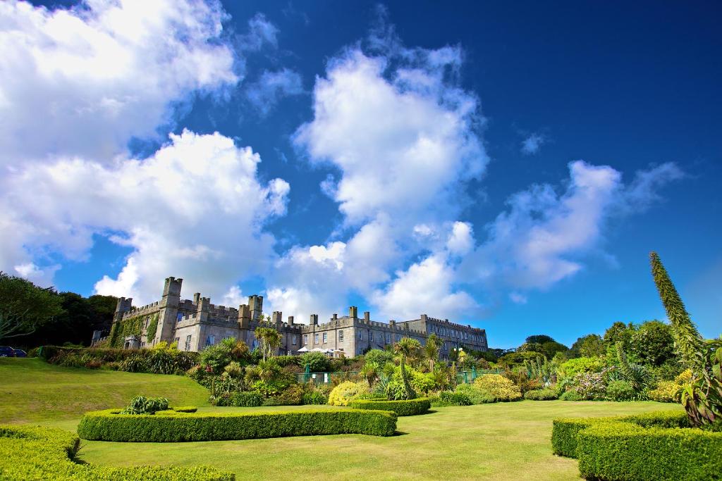 a castle on a hill with bushes and trees at Tregenna Castle Resort in St Ives