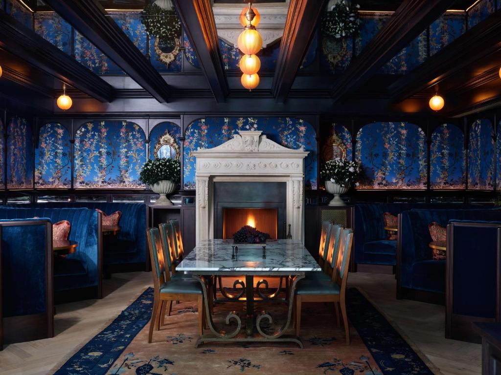 a dining room with a table and a fireplace at NoMad London in London