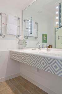 a bathroom with two sinks and a mirror at The St Enodoc Hotel in Wadebridge