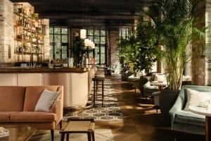 eine Lobby mit Sofas und eine Bar mit Pflanzen in der Unterkunft The Hoxton, Southwark in London