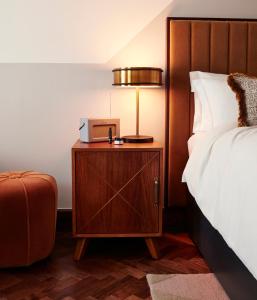 um quarto de hotel com uma cama e um candeeiro numa mesa de cabeceira em The Hoxton, Holborn em Londres