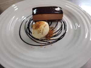 a white plate with a piece of chocolate and ice cream at St Tudy Inn in Bodmin