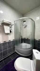 a bathroom with a glass shower and a toilet at Sultan Jalal-Abad in Jalal-Abad