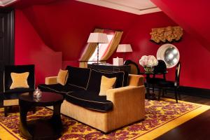 Sala de estar de color rojo con sofá y mesa en L'oscar London en Londres