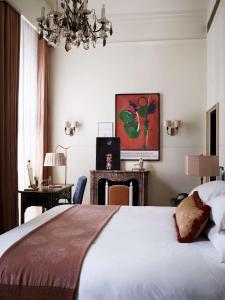 a bedroom with a large bed and a chandelier at NoMad London in London