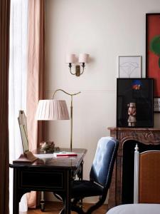 a bedroom with a desk and a chair and a lamp at NoMad London in London