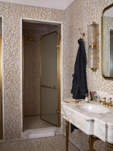 a bathroom with a sink and a shower with a mirror at NoMad London in London