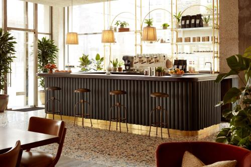 a kitchen with a black counter and stools at The Hoxton, Holborn in London