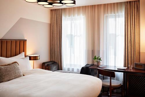 um quarto de hotel com uma cama, uma secretária e uma janela em The Hoxton, Holborn em Londres