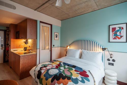 1 dormitorio con 1 cama grande con una manta colorida en room2 Chiswick Hometel en Londres