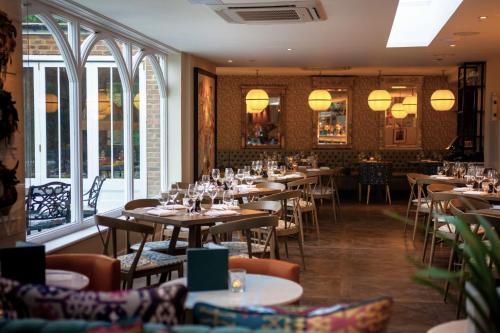 a dining room with tables and chairs and windows at Harbour Hotel & Spa Richmond in Richmond upon Thames