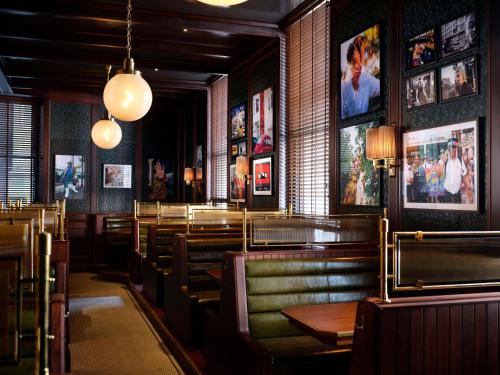 a restaurant with benches and pictures on the walls at NoMad London in London