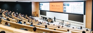 Conference attending a session in a large lecture hall.