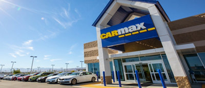 Uma foto do prédio Carmax com muitos carros estacionados do lado de fora