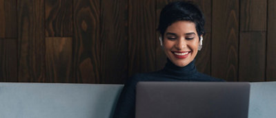 A woman sitting on sofa and working on her laptop