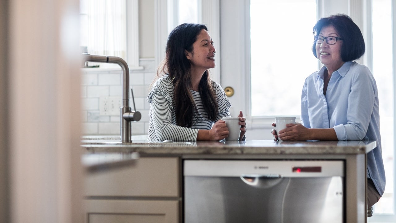 A mother and daughter have a discussion in the kitchen