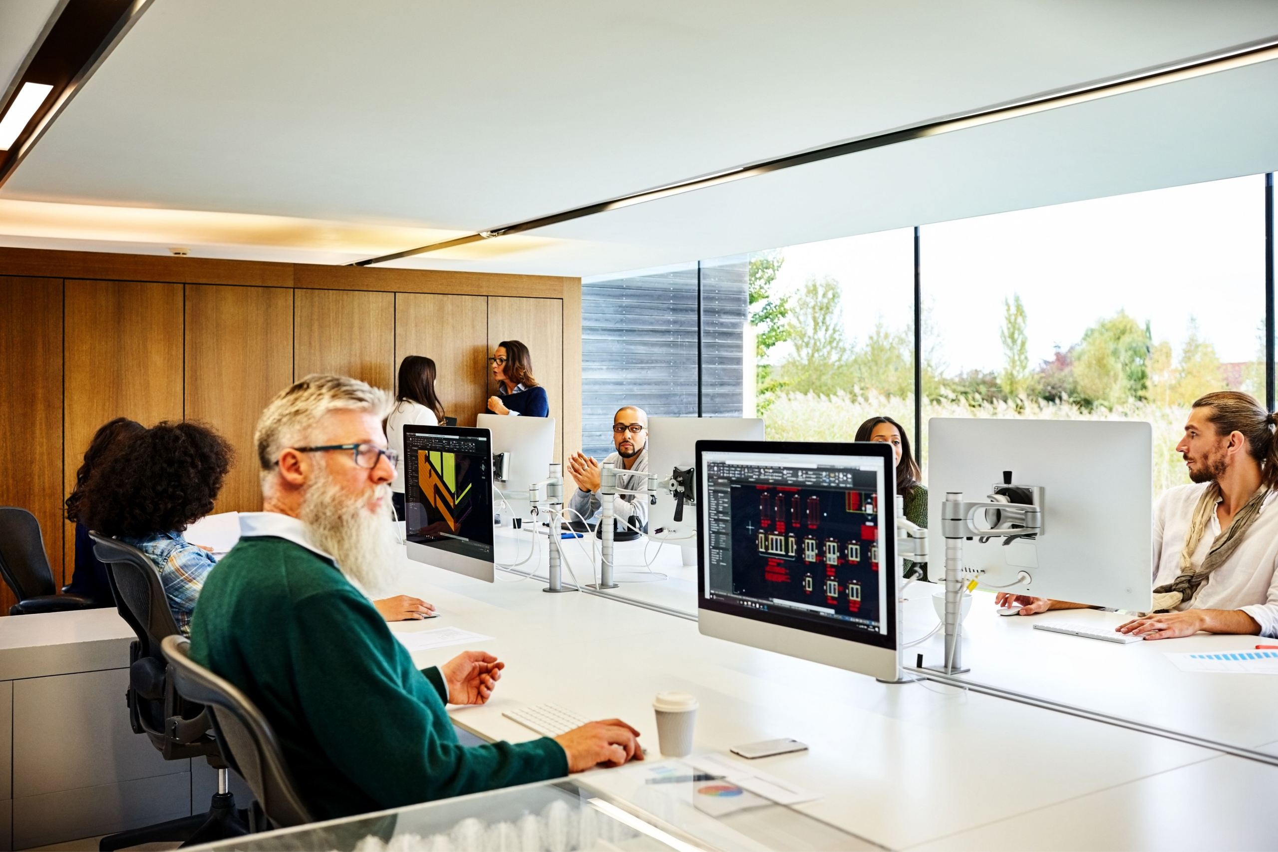 People in an office, working at their desk on computers.