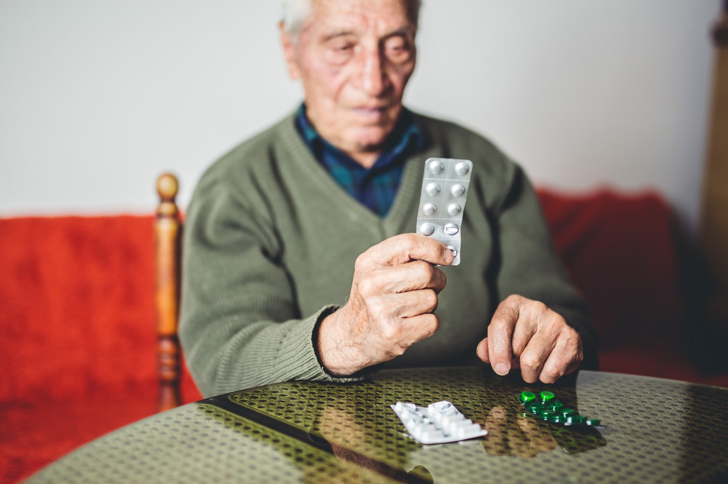 Elderly man holding his medicine