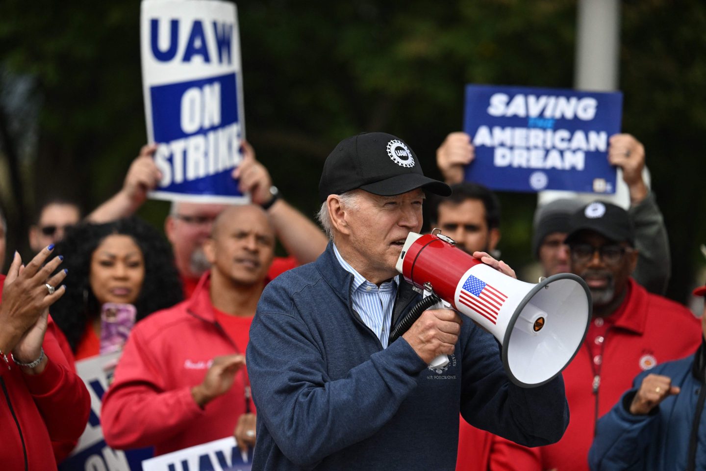 TOPSHOT &#8211; US President Joe Biden addresses striking members of the United Auto Workers (UAW) union at a picket line outside a General Motors Service Parts Operations plant in Belleville, Michigan, on September 26, 2023. Some 5,600 members of the UAW walked out of 38 US parts and distribution centers at General Motors and Stellantis at noon September 22, 2023, adding to last week&#8217;s dramatic worker walkout. According to the White House, Biden is the first sitting president to join a picket line. (Photo by Jim WATSON / AFP) (Photo by JIM WATSON/AFP via Getty Images)