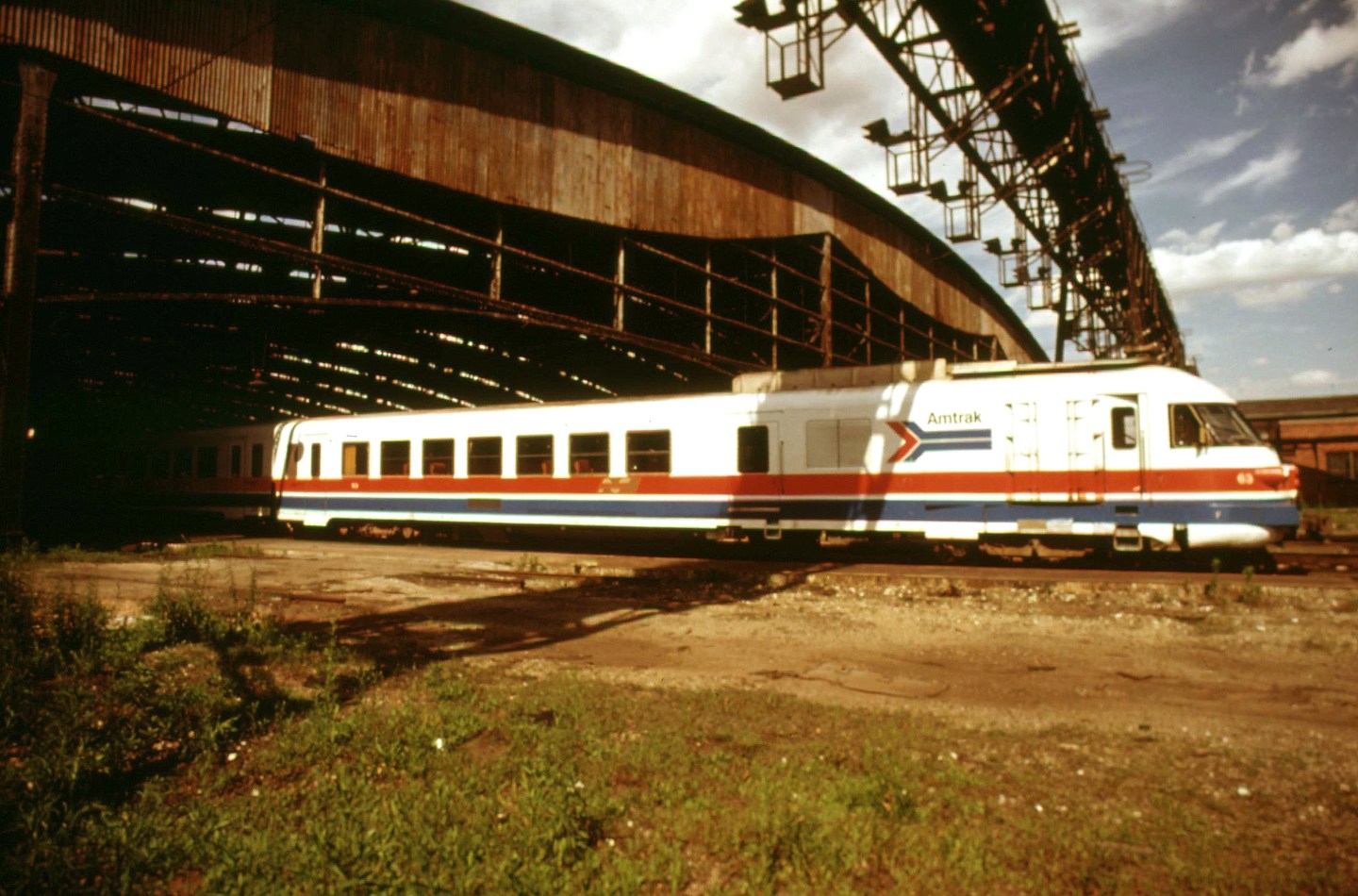 An archival photo of an Amtrak train by a bridge