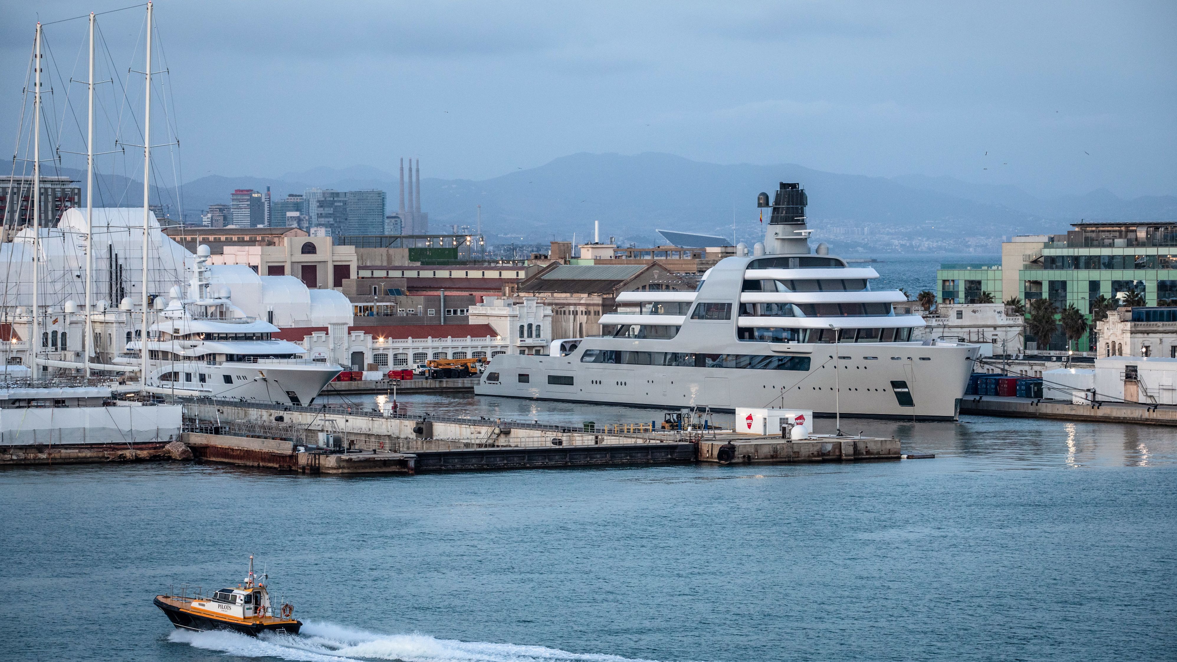 A pilot boat passes the Solaris superyacht, right, owned by Russian billionaire Roman Abramovich, in Barcelona, Spain, on March 1, 2022. The Russian billionaire handed direct control of Chelsea F.C. to the trustees of its charitable foundation and he's also selling his London properties, British lawmaker Chris Bryant said in Parliament. Photographer: Angel Garcia/Bloomberg/Getty Images