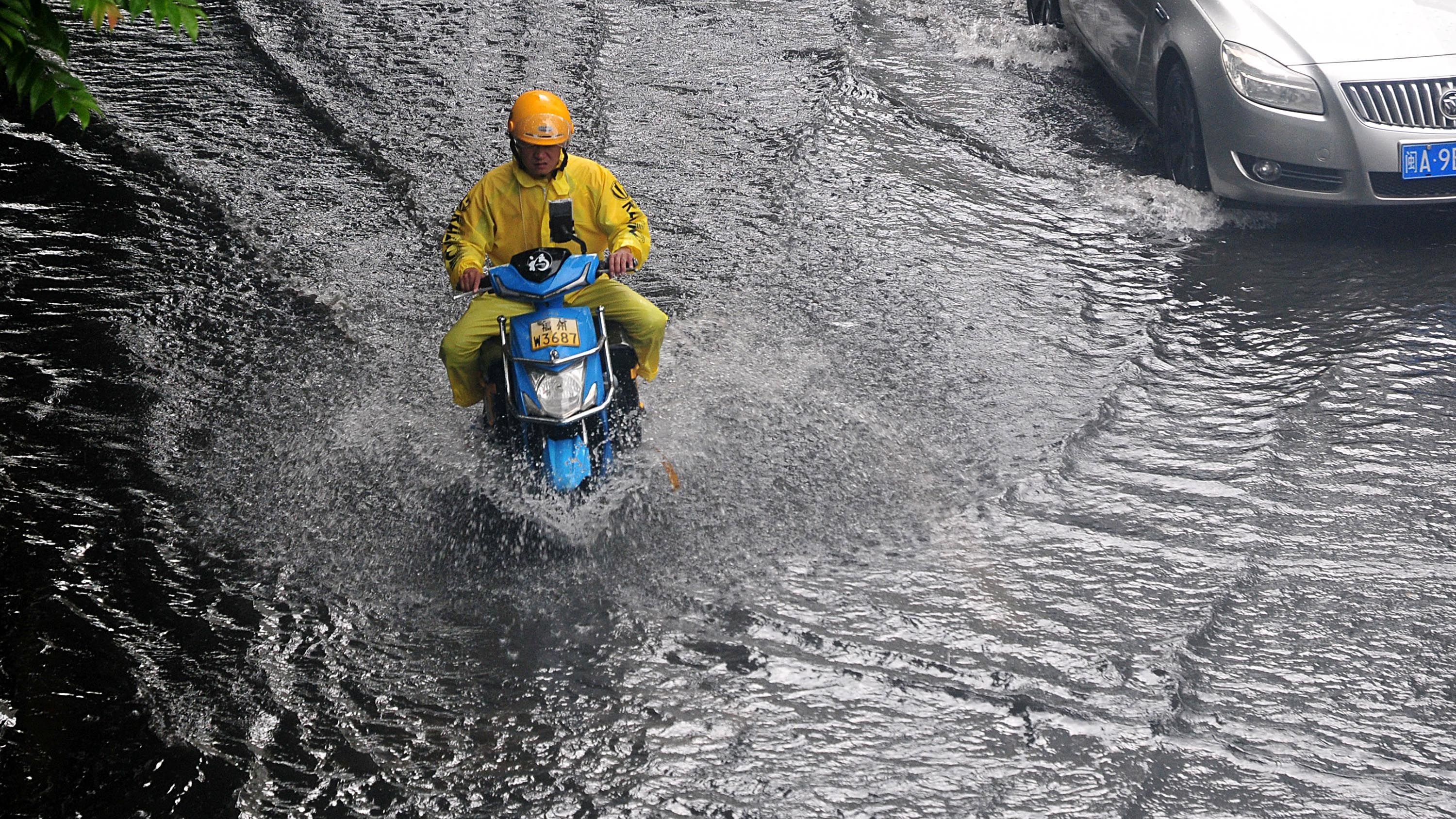 FUZHOU, CHINA - JUNE 16: A resident rides through a waterlogged road after a heavy rain on June 16, 2024 in Fuzhou, Fujian Province of China. The Fujian Provincial Meteorological Observatory continued to issue heavy rain warning. (Photo by Zhang Bin/China News Service/VCG via Getty Images)