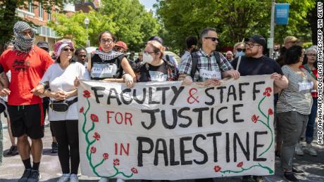 Students march while holding a sign during the pro-Palestine student protests that have turned into an encampment at George Washington University&#39;s Yard in a protest movement that has spread across universities in the U.S, demonstrating against Israeli military action in Gaza and calling on their university to stop doing business with companies they see as supporting the war on Wednesday, May 01, 2024. Despite the police crackdowns, the students have continued to rally and call for a ceasefire in Israel&#39;s war on Gaza. (Photo by Amid Farahi / Middle East Images / Middle East Images via AFP) (Photo by AMID FARAHI/Middle East Images/AFP via Getty Images)