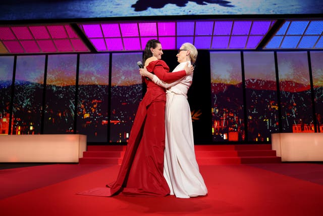 Juliette Binoche, left, embraces Meryl Streep during the opening ceremony of the 77th international film festival, Cannes, southern France 