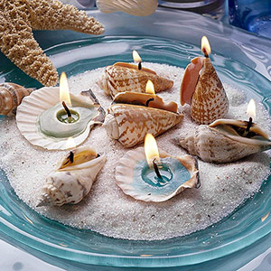 Seashell candles in dish with sand