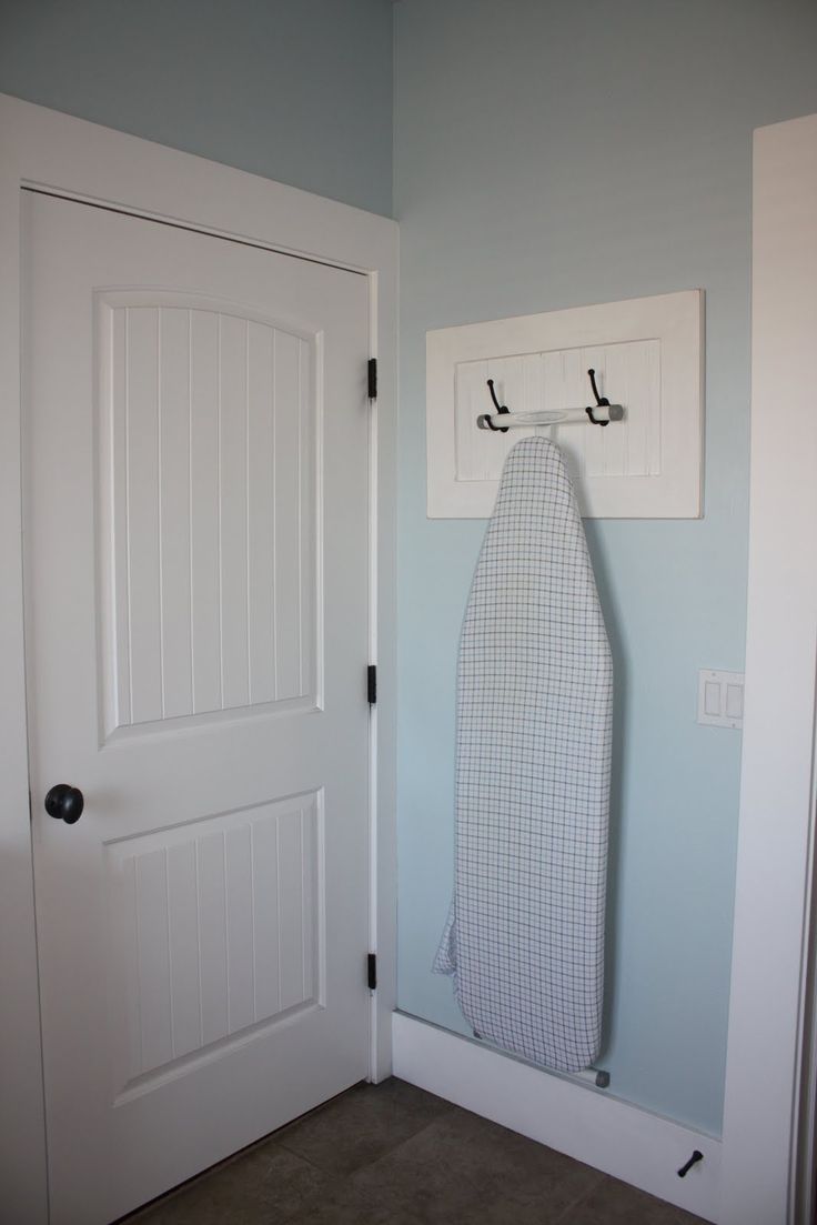 use 2 coat hooks to hang an ironing board