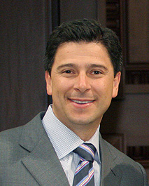 Head and shoulders of a smiling 40ish man with dark hair