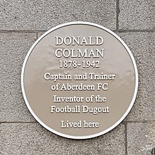 Circular, buff-coloured plaque with the text "Donald Colman 1878 -1942 Captain and Trainer of Aberdeen FC Inventor of the Football Dugout Lived Here