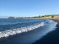 Plage de sable noir à Pīraʻe.