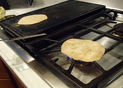 Chapati yang dimasak di atas api langsung setelah dimasak setengah matang dengan tava.