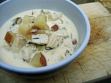 A bowl of fish chowder, with tilapia, red potato, chopped dill, and other ingredients