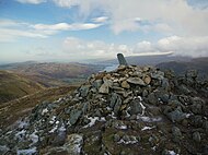 The summit cairn on Sheffield Pike, with stone boundary marker, and Ullswater beyond