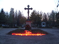 zentrales Friedhofskreuz des Friedhofes Speyer von Gottfried Renn mit Grablichtern