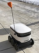A close up of a Starship delivery robot operating in the winter, with its camera array visible