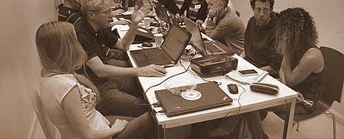 Photo noir/blanc de personnes à une table avec des ordinateurs portables