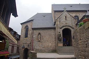 Entrada pel transsepte pel costat nord de l'església parroquial (amb estàtua de Joana d'Arc)