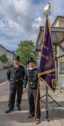 Das Foto zeigt zwei Kaminkehrer mit Banner