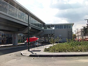 A picture of the station, an overground building supported by concrete columns.